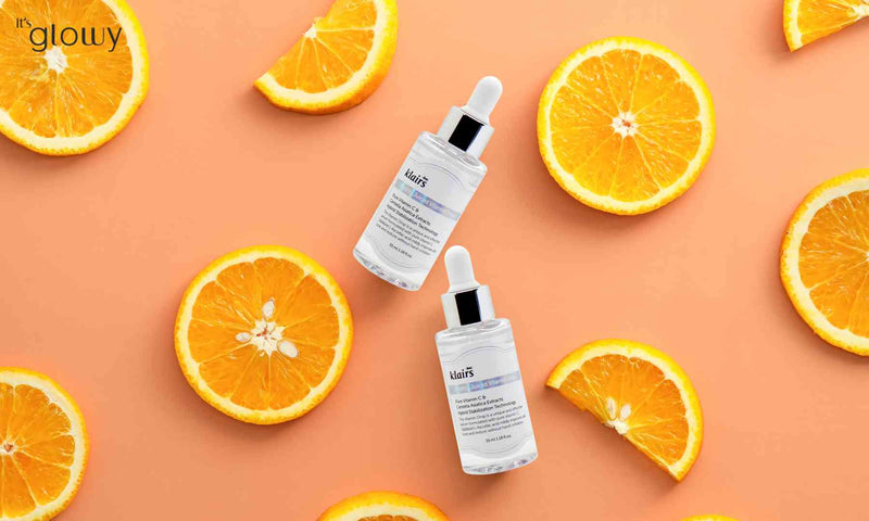 Bild von dear Klairs Freshly Juiced Vitamin C Drop Serum auf orangenem Hintergrund mit Orangenscheiben