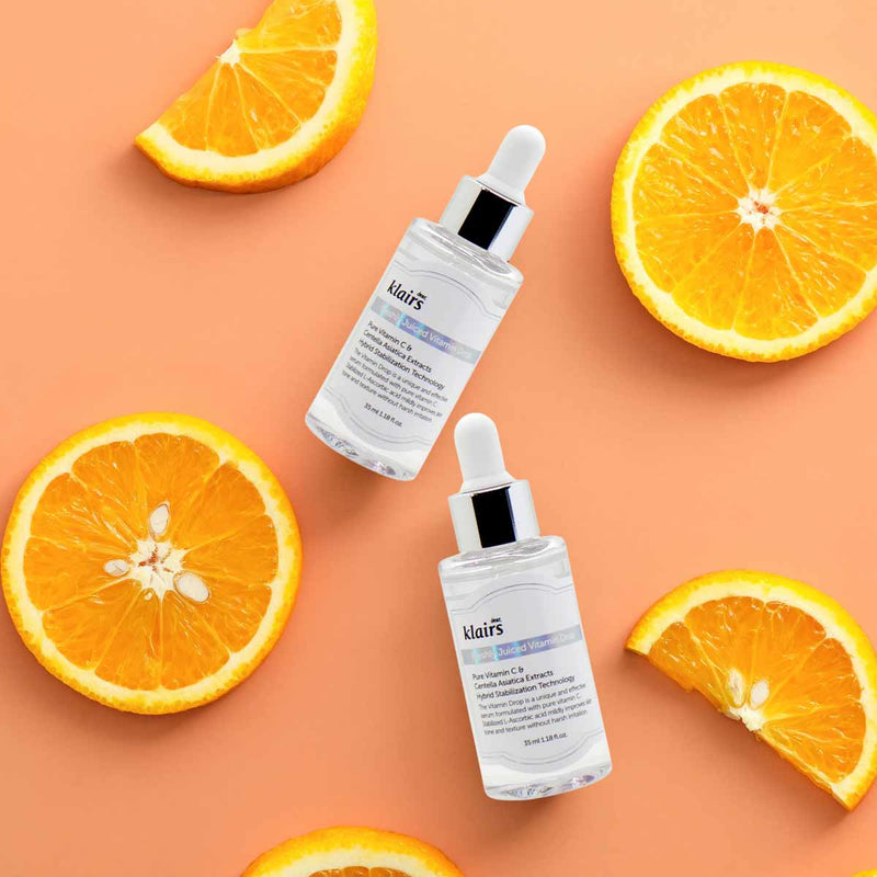 Bild von dear klairs Freshly Vitamin C Drop Serum auf orangenem Hintergrund mit Orangen